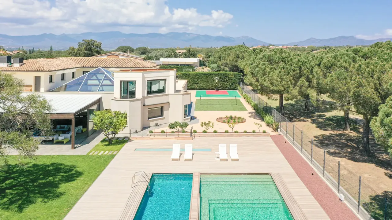 Aerial — two pools, sports courts and Pyrenees